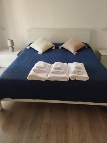 un letto con tre asciugamani pieghevoli sopra di Casa Angelina a Roma