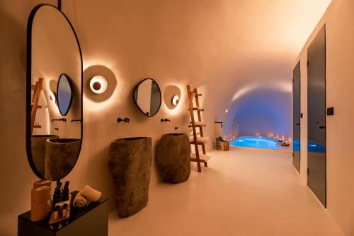 a room with mirrors and vases on the wall at Twenty One Suites in Oia