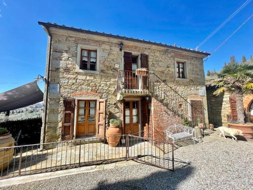 a stone house with a staircase in front of it at Borgo Dolci Colline Resort Ziraia in Castiglion Fiorentino