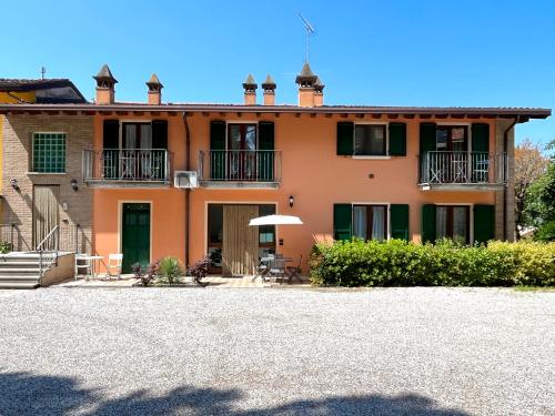 a large orange house with a patio in front of it at Residence la Lucciola in Lonato del Garda