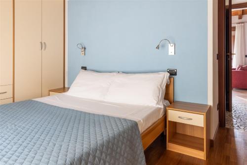 Schlafzimmer mit einem Bett mit blauer Wand in der Unterkunft IseoLakeRental - La Magia del Lago in Ranzanico