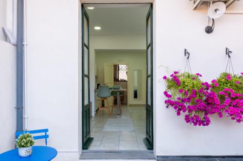 drzwi prowadzące do pokoju z różowymi kwiatami w obiekcie Majolica Home w mieście San Gregorio di Catania