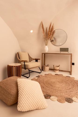 a room with a chair and a mirror and a rug at Twenty One Suites in Oia