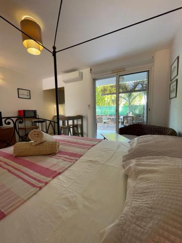 1 dormitorio con 1 cama grande y ventana grande en Prana Lodge Saint Gilles les Bains 800 m de la plage, en Saint-Gilles-les-Bains