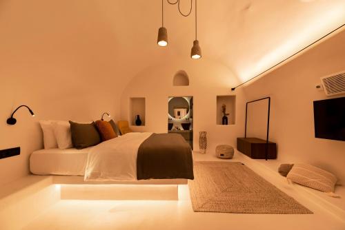 a bedroom with a bed and a television in it at Twenty One Suites in Oia
