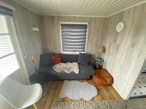 een woonkamer met een blauwe bank en een raam bij Vacation house MAX for 4 persons, 350 m from the sea, in Pollentier Middelkerke Park in Middelkerke