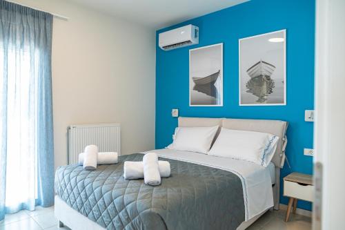 a blue bedroom with a bed with white pillows at Villa Eos Mastichari - with heated pool in Mastichari