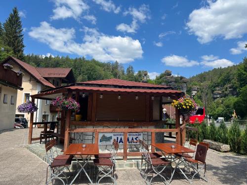 eine Terrasse mit Tischen und Stühlen vor einem Gebäude in der Unterkunft Jamas Hotel & Restaurant in Pottenstein