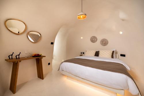 a bedroom with a bed and a table with mirrors at Twenty One Suites in Oia