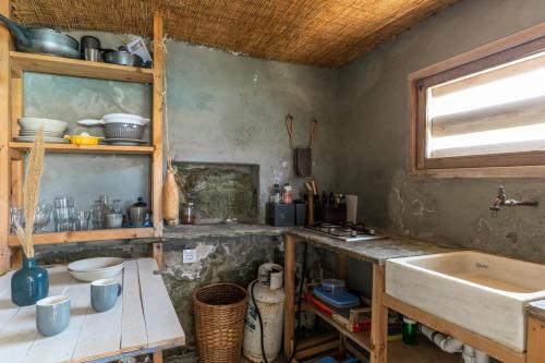 a kitchen with a sink and a counter and a window at The Fishermans Experience Tinos in Platiá