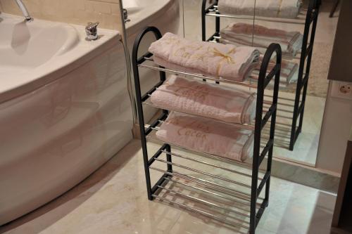 - un porte-serviettes dans la salle de bains à côté d'un lavabo dans l'établissement Apartman De Lux - Cacak, à Čačak
