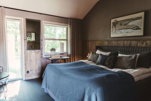 een slaapkamer met een groot bed en een blauwe deken bij Tweed Hotell Skaftö in Fiskebäckskil