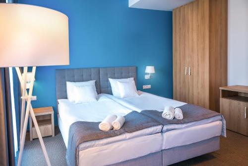 ein Schlafzimmer mit einem Bett und Hausschuhen darauf in der Unterkunft Hotel Arkadia Jelcz-Laskowice in Jelcz