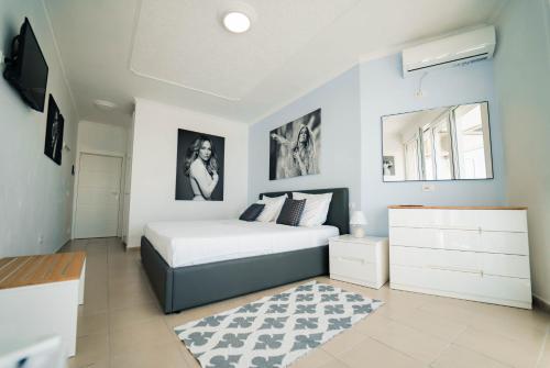 a bedroom with a bed and a dresser in it at Beachfront Marilyn in Durrës