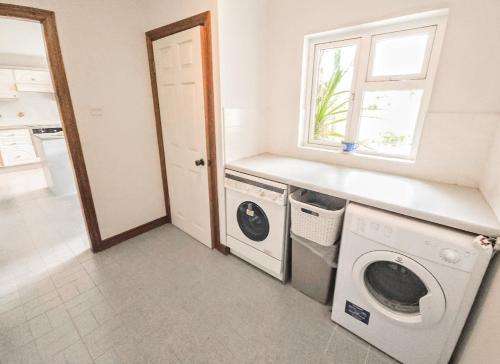 a laundry room with a washing machine and a window at Lark Rise Holiday Home Glenbeigh by Trident Holiday Homes in Glenbeigh