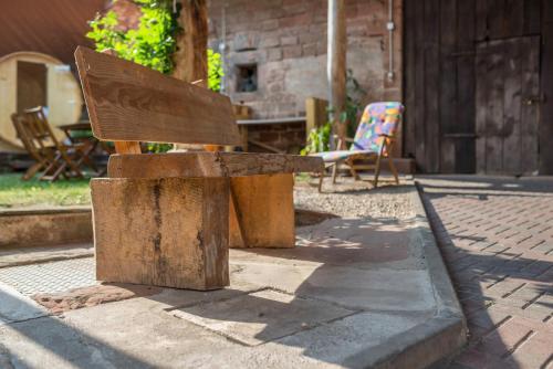 a wooden bench sitting on the side of a sidewalk at Pfälzerwald Idyll in Schwanheim
