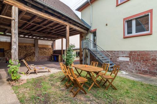 a patio with a wooden table and chairs at Pfälzerwald Idyll in Schwanheim