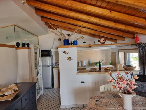 una cucina con soffitti in legno e un tavolo in una camera di Villa Sicily Sul Mare Tra Catania e Siracusa ad Augusta