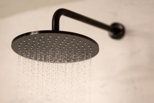 a shower head with water droplets on a wall at Twenty One Suites in Oia