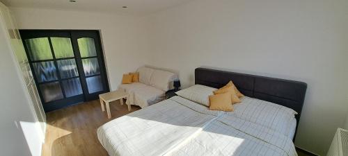 a bedroom with a bed and a chair and a window at Pension ANDREA in Mikulov