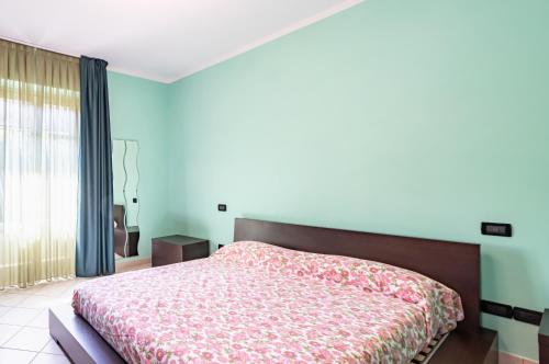a bedroom with a bed with a floral bedspread at Sesto di Moriano-Cozy Apt with Garden&Parking! in Lucca