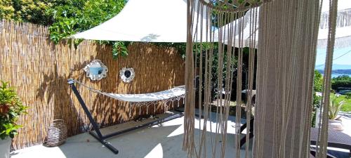 a hammock in a backyard with a fence at Wooden Summer House in Mantoúkion