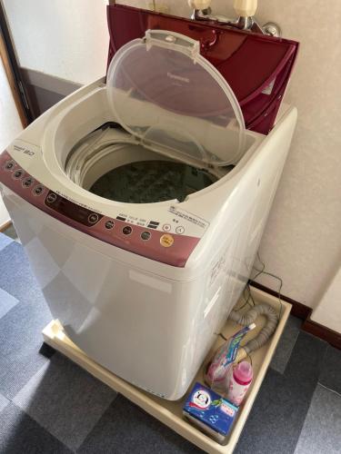 a washing machine with its lid open in a room at 高島市一棟貸切 グループファミリーok Biwa Lake琵琶湖 徒歩10分 大人数でご利用だとお得連泊がお得BBQ可能自転車麻雀卓無料利用可 in Takashima