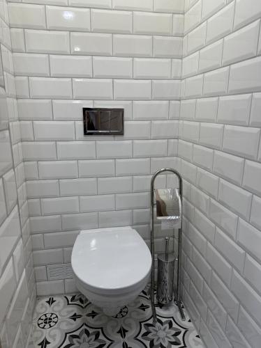 La salle de bains est pourvue de toilettes et d'un mur en carrelage blanc. dans l'établissement Pärnu Sunshine Majutus, à Pärnu