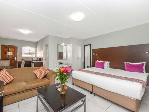 Habitación de hotel con cama y sofá en Mercure Hotel Nelspruit en Nelspruit