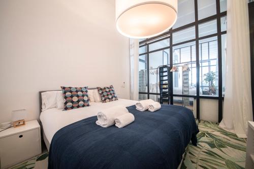 a bedroom with two beds and a large window at Poble Nou I You Stylish Apartments in Barcelona