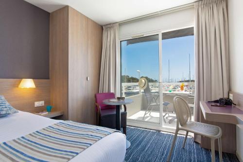 una camera con letto e balcone di Best Western Plus La Marina a Saint-Raphaël