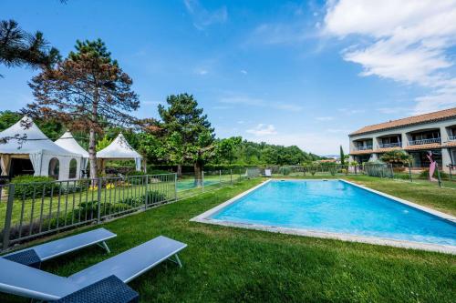 a swimming pool in the yard of a house at Best Western Plus Clos Syrah in Valence