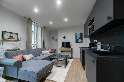 a living room with a couch and a kitchen at Résidence Aristide Briand - Appartements en Centre Ville in Vichy