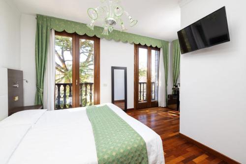 a bedroom with a bed and a flat screen tv at Hotel Villa Cipro in Venice-Lido