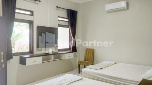 Postel nebo postele na pokoji v ubytování The SO Hotel Mitra RedDoorz
