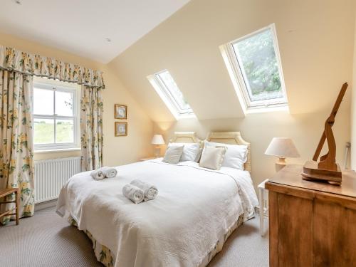 a bedroom with a large bed with towels on it at The Coach House in Ingoldsby