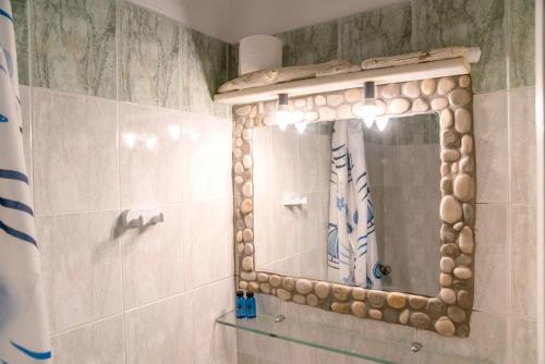 un baño con espejo y ducha en Green Retreats 1 Paros, en Isterni