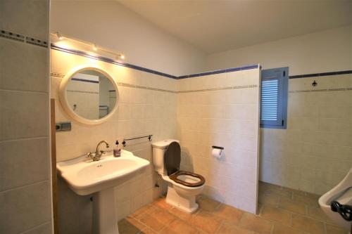 a bathroom with a toilet and a sink and a mirror at RA694 Casa con piscina de 4 dormitorios in Cuevas del Almanzora