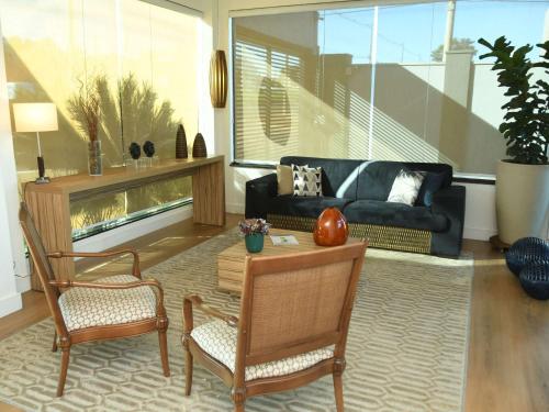 a living room with a couch and a table and chairs at Hotel Araraquara By Mercure in Araraquara