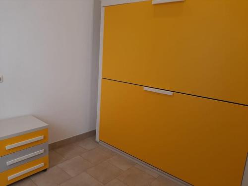 a large yellow cabinet in a corner of a room at Casa vacanze Gemini in Triscina