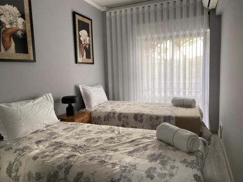 a bedroom with two beds and a window at Estoril Casino 3 Bedrooms With Pool in Estoril