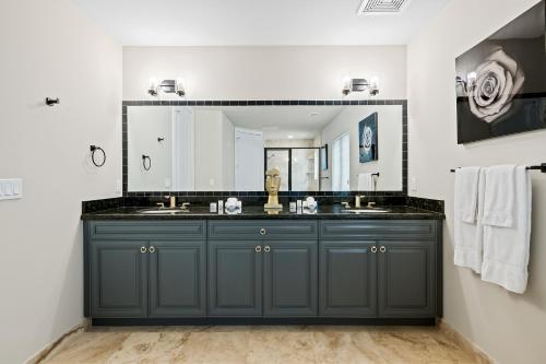 baño con tocador azul oscuro y espejo grande en Casa Central: In the Heart of Fort Lauderdale!, en Fort Lauderdale