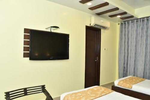 a room with two beds and a flat screen tv on the wall at PARK PRIDE INN in Patna