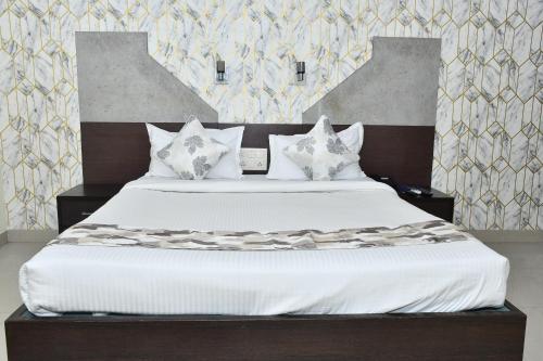 a bedroom with a large bed with white sheets and pillows at PARK PRIDE INN in Patna