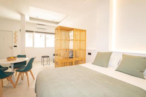 1 dormitorio blanco con 1 cama, mesa y sillas en center cathedral suite en Granada
