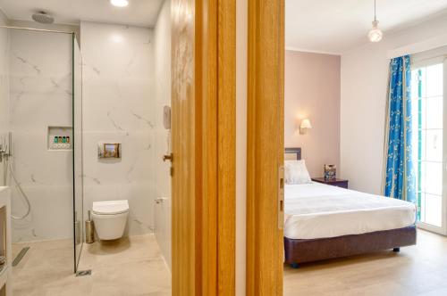 sypialnia z łóżkiem, prysznicem i toaletą w obiekcie Oscar Hotel w Laganas