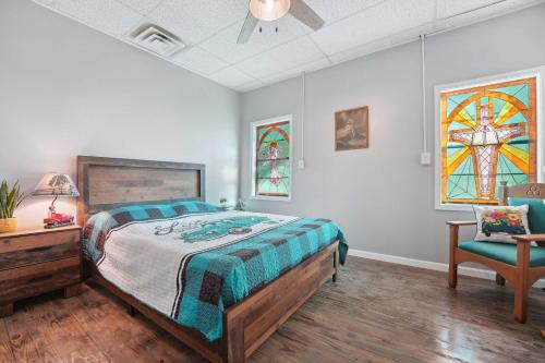 a bedroom with a bed and a chair and stained glass windows at Old Church Retreat with Fire Pit and Air Hockey! in Omaha