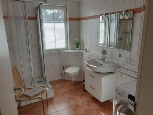 a white bathroom with a sink and a toilet at Möwenblick Nr 3 - für die schönste Zeit des Jahres - all inclusive - Wäschepaket - PowerWLAN - eigene Fahrradbox mit Stromanschluß und kostenfreier Parkplatz in Zingst