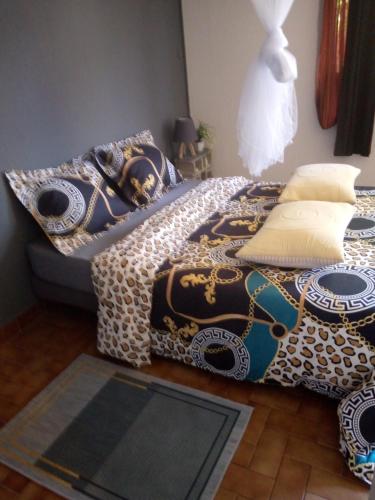 een slaapkamer met een bed met een blauwe en witte deken bij La Chambre de Cosy in Libreville