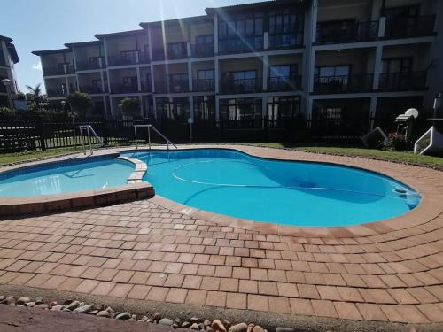 einem Pool vor einem Gebäude in der Unterkunft Topanga Holiday Apartment in Uvongo Beach